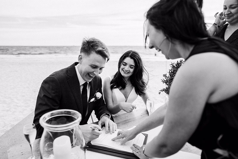 Bride and Groom signing at their wedding at The Sandbar Beach Cafe