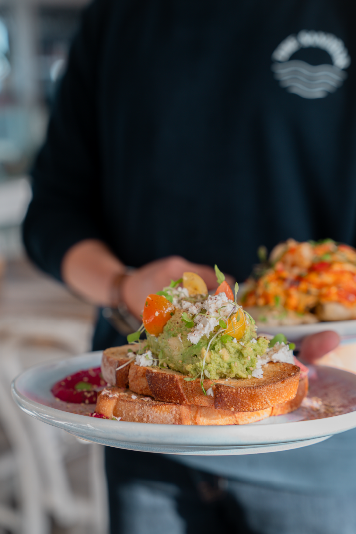 Avo smash from the menu being held by staff member.