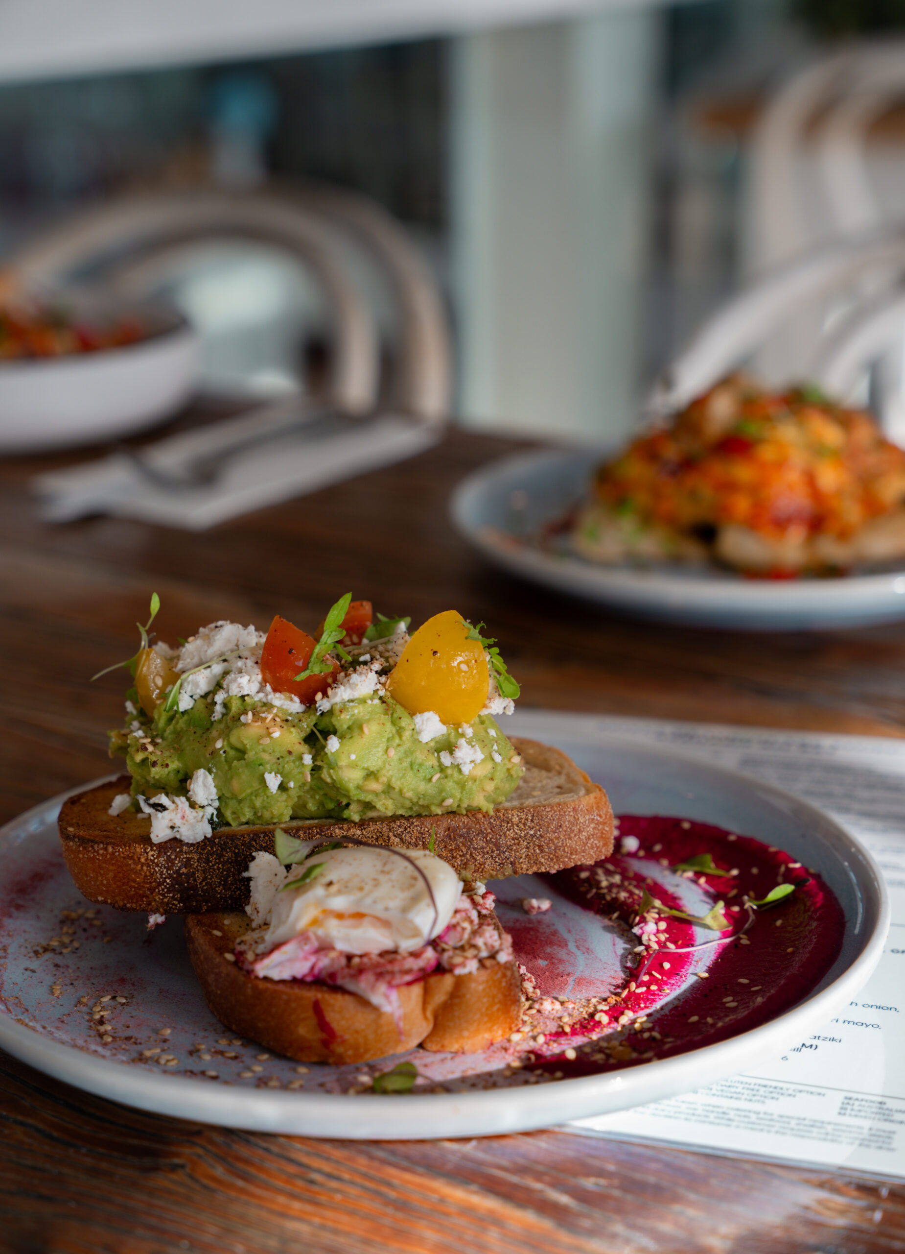 Smashed avocado on sourdough with feta and poached eggs at Sandbar Beach Café
